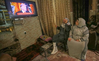 Dos palestinos ven al presidente estadounidense, Donald Trump, hablando por televisión el pasado 28 de enero.