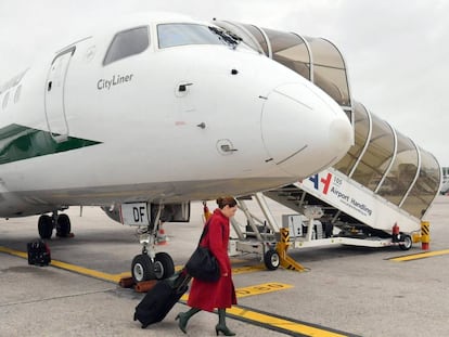 Una azafata embarca un avi&oacute;n de la aerol&iacute;nea italiana Alitalia en el aeropuerto de Mil&aacute;n.