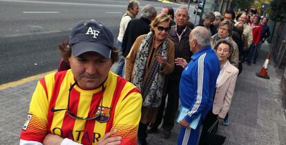 Colas de ciudadanos esperan en la Vía Augusta de Barcelona