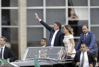 O presidente Jair Bolsonaro desfila por Brasília acompanhado da primeira-dama, Michelle, e de um de seus filhos, Carlos Bolsonaro. 