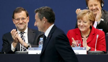 El presidente del Gobierno, Mariano Rajoy (d), junto a la canciller alemana, Angela Merkel (i), aplauden al expresidente francés y líder de Los Republicanos franceses, Nicolas Sarkozy.