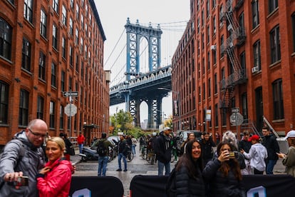 Turistas se fotografían, en Brooklyn, Nueva York, con el puente de Manhattan de fondo.