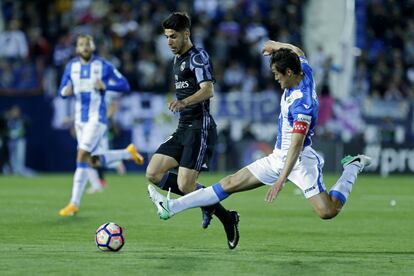El jugador del real Madrid, Marco Asensio, pelea la pelota con el jugador del Leganés, Martín Mantovani.