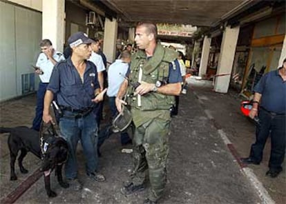 Miembros de las fuerzas de seguridad israelíes inspeccionan la zona de la explosión.