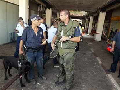 Miembros de las fuerzas de seguridad israelíes inspeccionan la zona de la explosión.