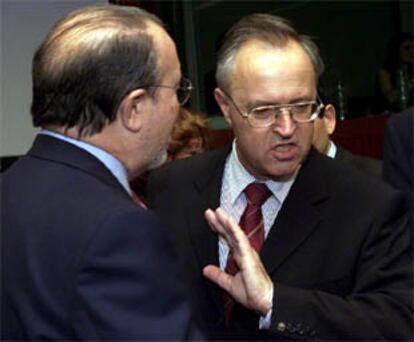 Pedro Solbes (izquierda) conversa con el ministro alemán Hans Eichel ayer en Bruselas.
