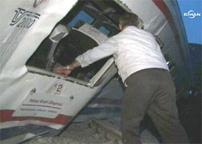 Imagen de televisión que muestra a una persona que intenta rescatar a las víctimas del accidente.