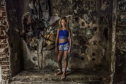 Roberta, de 11 anos, na frente do vão do antigo elevador, atualmente cheio de lixo, no edifício abandonado do IBGE. Favela da Mangueira, Rio de Janeiro.