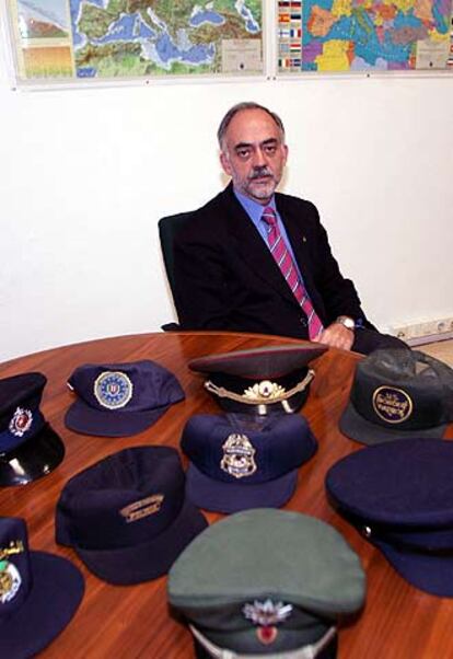 Gil Arias, ante su colección de gorras de policías europeas.
