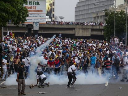 Un grupo de manifestantes se enfrenta con la policía hoy en Caracas.