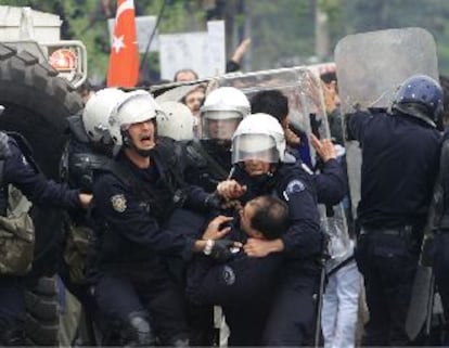 Un grupo de policías pide ayuda para un agente herido en los disturbios de ayer en Ankara.