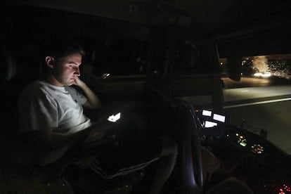 Un joven mira su móvil durante el trayecto nocturno.