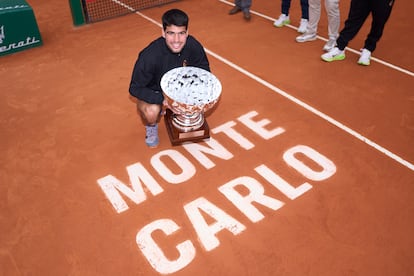 Alcaraz posa con el trofeo en la pista tras el partido.