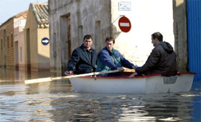 Vecinos de Pradilla de Ebro (Zaragoza), localidad inundada por el desbordamiento del río, intentaban ayer llegar a sus casas en barca.