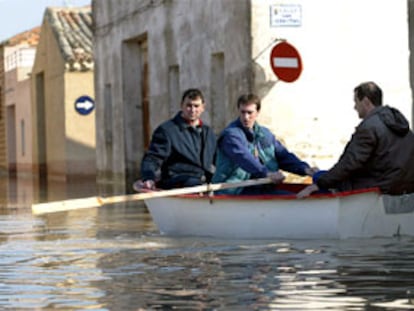 Vecinos de Pradilla de Ebro (Zaragoza), localidad inundada por el desbordamiento del río, intentaban ayer llegar a sus casas en barca.