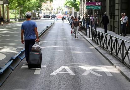 Un pasajero camina por el carril bus vac&iacute;o en Madrid.