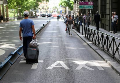 Un pasajero camina por el carril bus vacío en Madrid.