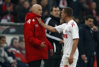 Podolski, delantero del Colonia, agarra por el cuello a su entrenador, Stole Solbakken, tras ser expulsado en el partido ante el Hertha (1-0)