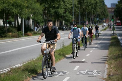 Diverses persones es mouen en bicicleta per un carril bici de Barcelona. 