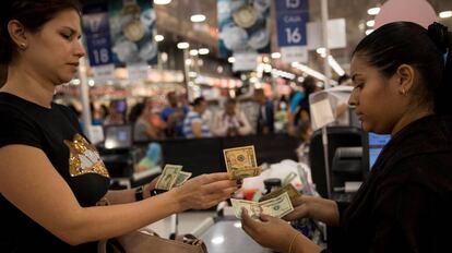 Una mujer paga sus compras en dólares, en un supermercado de Caracas. 