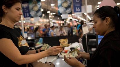 Una mujer paga sus compras en dólares, en un supermercado de Caracas.