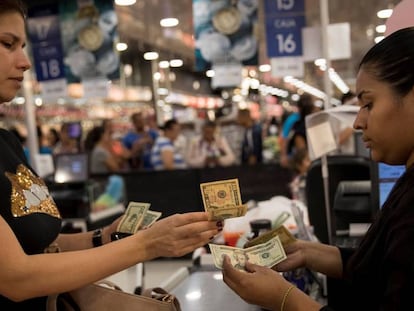 Una mujer paga sus compras en dólares, en un supermercado de Caracas. 
