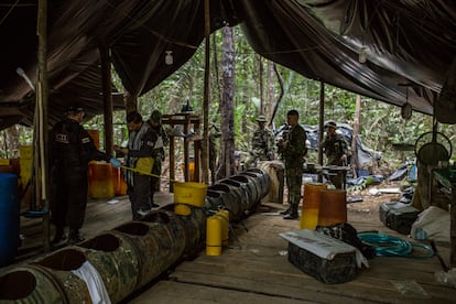 Soldados y policía judicial documentan el escenario de un laboratorio masivo de clorhidrato de cocaína hallado en el Guaviare en mayo de 2019. El "gusano", el tubo de barriles conectados, funciona como baño maría para la conversión de pasta base en clorhidrato de cocaína.