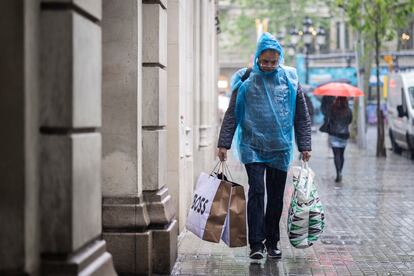 Un hombre se protege de la lluvia en el centro de Barcelona, el pasado lunes.