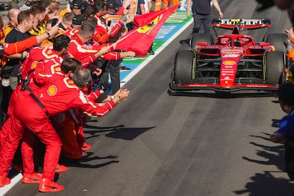 El piloto de Ferrari Carlos Sainz es recibido por su equipo tras cruzar la línea de meta este domingo en Melbourne. 
