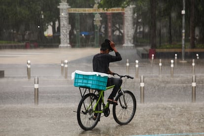 El SMN ha señalado que la zona de prevención va desde Acapulco, en Guerrero, hasta Punta de San Telmo, en Michoacán. En la imagen, un joven monta su bicicleta durante las intensas lluvias ocasionadas por la tormenta tropical, en Acapulco. 