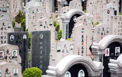 A man (R) repaints the engravings on a gravestone during the annual "Qingming" festival, or Tomb Sweeping Day, at a public cemetery in Shanghai on April 4, 2016.
During Qingming, Chinese traditionally tend the graves of their departed loved ones and often burn paper offerings to honour them and keep them comfortable in the afterlife. / AFP PHOTO / JOHANNES EISELE