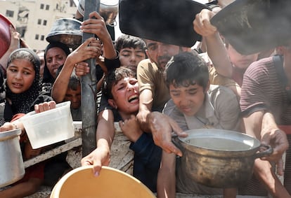 Palestinos intentan conseguir comida en una cocina de caridad en Ciudad de Gaza, este lunes.