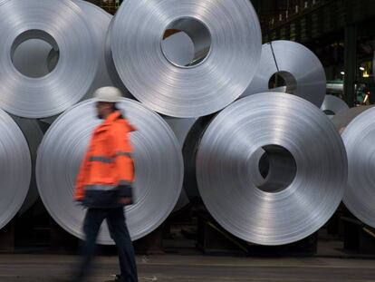 Un trabajador pasa por delante de varias bobinas de acero en la planta siderúrgica alemana Salzgitter AG.