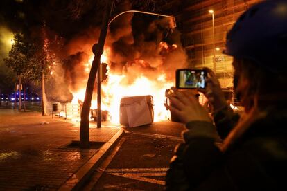 Una persona graba una barricada en llamas en Barcelona.