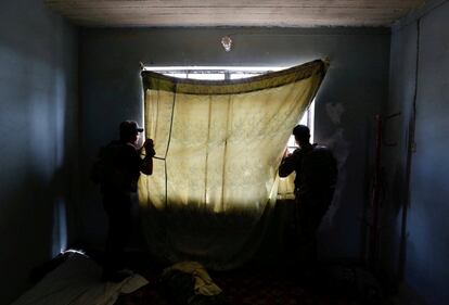 Members of Iraqi Counter Terrorism Service (CTS) forces look at the positions of Islamic State militants during clashes in western Mosul, Iraq, May 15, 2017. Danish Siddiqui: "In May, I was accompanying a senior commander of Counter Terrorism Service, an elite Iraqi security force trained by the US, during the battle to take control of Western Mosul. We arrived at a small house on the frontline after walking through holes in the walls between homes. Islamic State snipers were firing a few hundred meters away. The people who once lived there departed quickly, leaving clothes and toys scattered across the floor. The next inhabitants left hollow shell casings. The CTS had taken over the house a day ago. The curtain was a bed sheet. They stood behind it to identify enemy snipers and watch one of their own. It's a quiet picture that tells of even the most uneventful of moments on the front, when nothing may happen, and everything is possible." REUTERS/Danish Siddiqui/File photo        SEARCH "MOSUL PICTURES" FOR THIS STORY. SEARCH "WIDER IMAGE" FOR ALL STORIES. ?