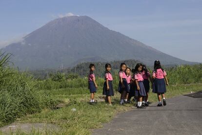 Estudiantes en un camino con el volcán Monte Agung de fondo en Karangasem, Bali.