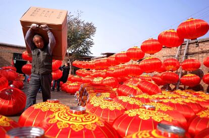 Un hombre lleva una caja de linternas, en una aldea de Shijiazhuang (China). 
