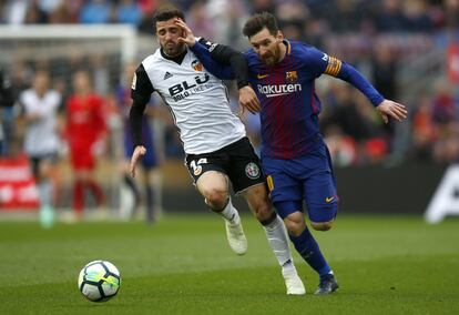 Lionel Messi (derecha) y José Luis Gaya luchan por el balón.