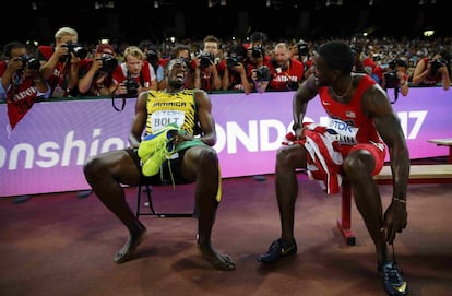 El jamaicano Bolt y el norteamericano Gatlin, ambos con las banderas de sus países, comentan la carrera. 