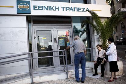 Tsipras reclamó la ampliación de los plazos de devolución al tiempo que llamó a la calma a la población, a la que prometió que sus depósitos bancarios están completamente asegurados. En la imagen, un grupo de ancianos espera la apertura de una oficina bancaria en Atenas, el 29 de junio de 2015.