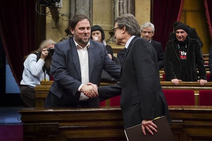 El líder de ERC, Oriol Junqueras felicita al presidente de la Generalitat en funciones, Artur Mas, tras la votación del pleno en el Parlament catalán.