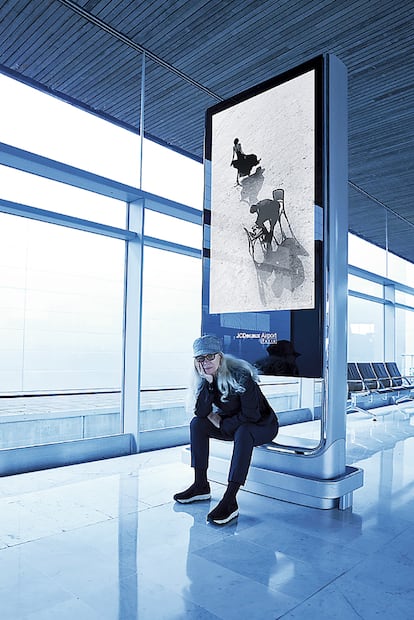 Dominique Issermann posando para Ollivier Hersart ante uno de los paneles de su exposición en el aeropuerto parisino de Charles de Gaulle (2016).