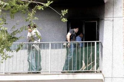 Técnicos de los bomberos de la Generalitat inspeccionan el piso incendiado.