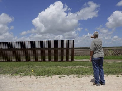 Un hombre señala un tramo de la valla fronteriza incompleta en Brownsville (Texas)