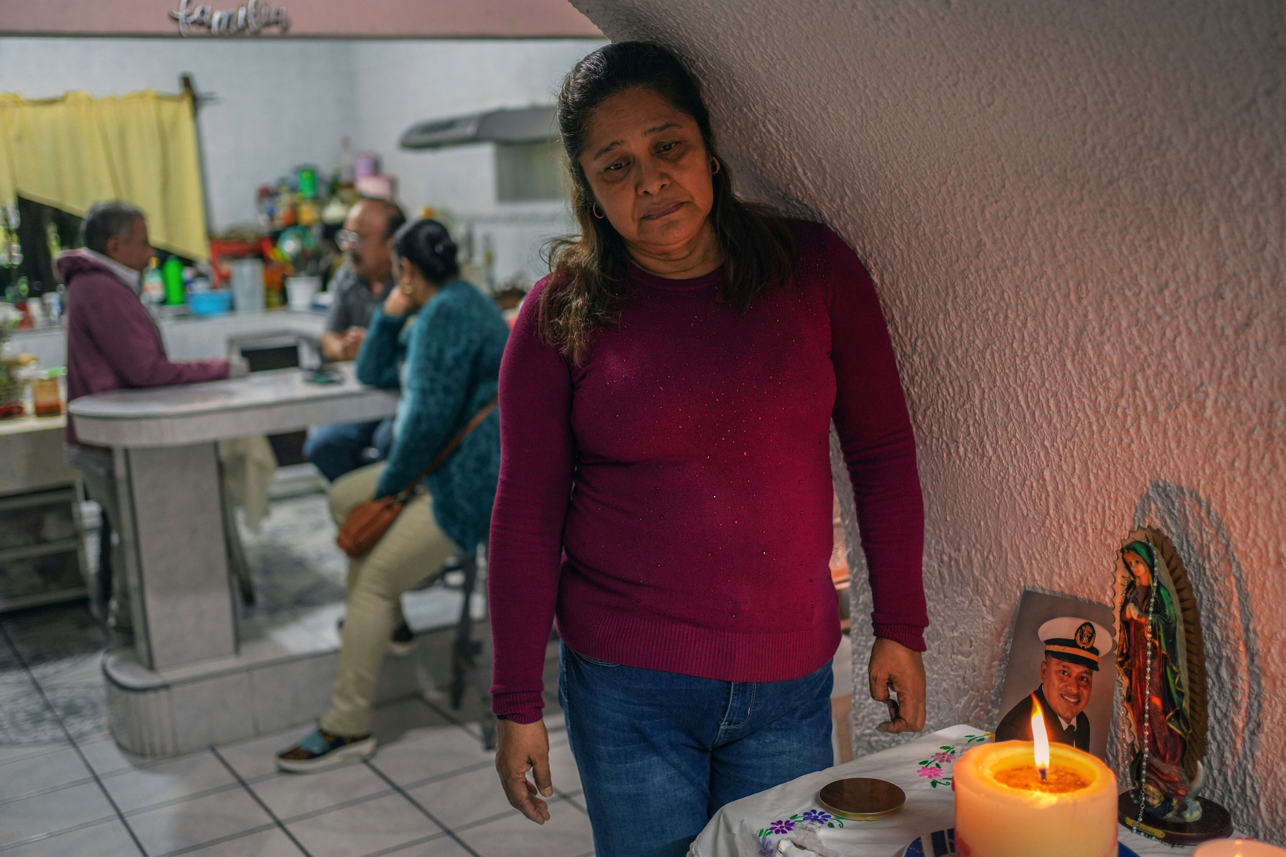 María Meza, madre de Arturo Zacarías Meza, uno de los marineros, enciende una veladora junto a la foto de su hijo, en Misantla (Veracruz), en noviembre.