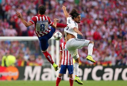 Raul Garcia del Atl&eacute;tico (i) y Sami Khedira del Real Madrid (d) pelean por un bal&oacute;n. 