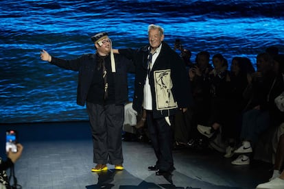 El diseñador Steven Stokey-Daley y el actor Ian McKellen saludan al público congregado en el desfile del primero, donde el segundo vistió sus prendas, el 19 de febrero de 2023 en la semana de la moda de Londres.