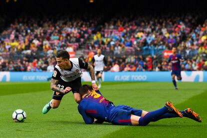 Santi Mina (izquierda), del Valencia, sigue la trayectoria de la pelota después de una jugada con Gerard Piqué.