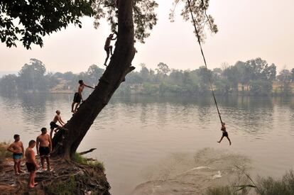 Un grupo de jóvenes saltan al río Penrith durante la ola de calor en Sydney (Australia).