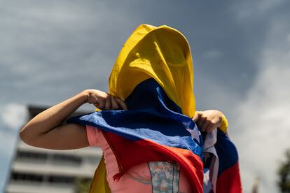 Una joven se cubre con una bandera venezolana, durante la concentración en Bogotá. 